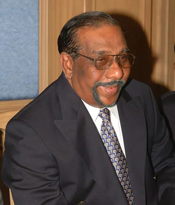 Portrait d’Anton Balasingham, stratège politique de la LTTE, en buste, fond neutre.