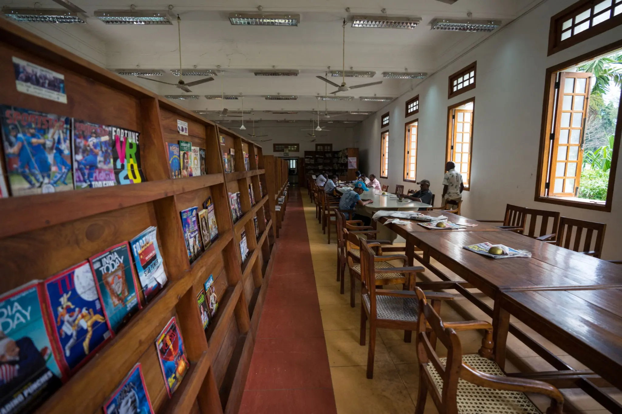 Salle de lecture de la bibliothèque de Jaffna, avec rayonnages de livres et tables de consultation.